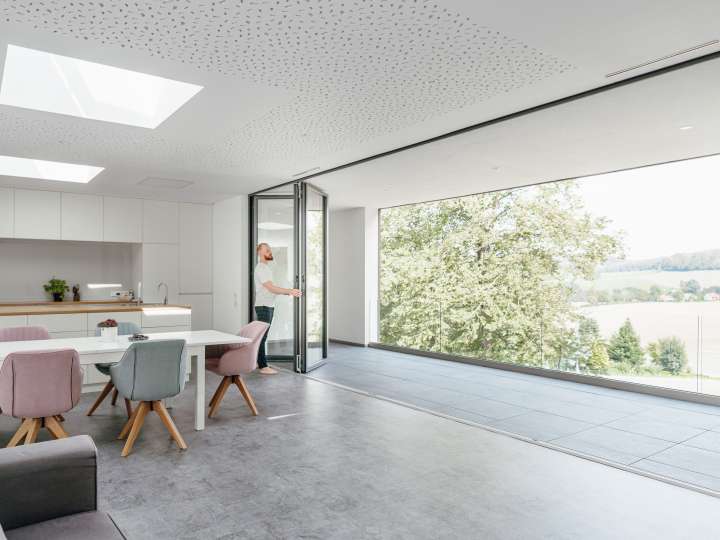 Mann öffnet eine Solarlux Glas-Faltwand